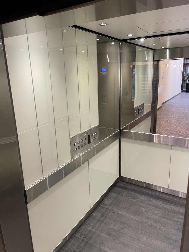 Electra Lift Interior, white colour back glass, elevator glass interior